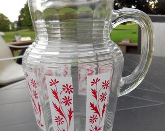 Mid century modern glass pitcher with ice lip and red floral design