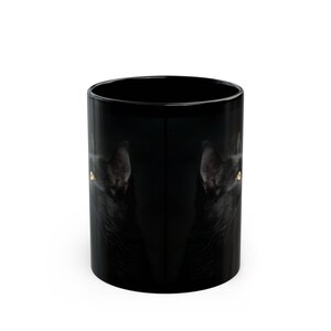 Pu&ograve; includere: Tazza da caff&egrave; nera con l'immagine di un gatto nero con gli occhi gialli. Sono visibili anche le orecchie del gatto. La tazza ha una finitura lucida ed &egrave; di dimensioni standard.