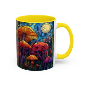 Peut inclure: Mug en c&eacute;ramique blanche avec int&eacute;rieur et anse jaunes. L'illustration color&eacute;e repr&eacute;sente des champignons dans une for&ecirc;t sous la pleine lune. Les champignons sont de diff&eacute;rentes nuances de rouge, orange et violet.