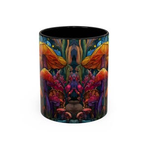 Peut inclure: Un mug en c&eacute;ramique noir et blanc avec une illustration sym&eacute;trique de champignons et de feuillages color&eacute;s. Le motif pr&eacute;sente des teintes orange, rouge, violet et vert, cr&eacute;ant une esth&eacute;tique fantaisiste et fantasmagorique. L'int&eacute;rieur du mug est noir.