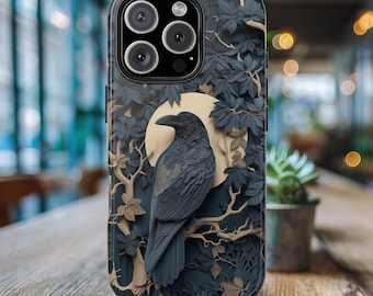 May include: A black phone case with a raven perched on a branch in front of a moon. The case has a dark blue and brown background with intricate paper cut-out designs.