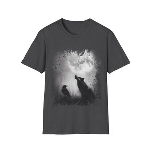 Pu&ograve; includere: T-shirt grigio scuro con grafica in bianco e nero di un lupo che ulula alla luna e un corvo. Il design ha un effetto invecchiato e strutturato. La maglietta ha girocollo e maniche corte.