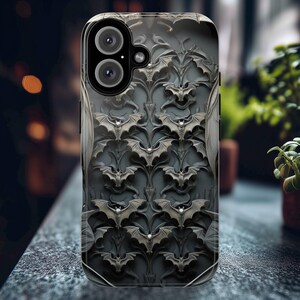 May include: A black phone case with a repeating pattern of bats on a dark gray background. The case has a camera lens cutout with two black circles.