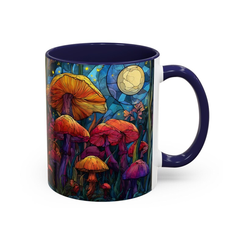 Peut inclure: Mug en c&eacute;ramique blanche avec int&eacute;rieur et anse bleu fonc&eacute;. L'illustration color&eacute;e repr&eacute;sente des champignons dans une for&ecirc;t, avec une pleine lune en arri&egrave;re-plan. Le design comprend des nuances d'orange, de rouge et de violet.