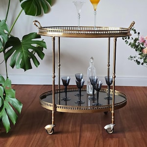 金色のトロリーバーカート、メゾン ジャンセン、ミッドセンチュリー オーバル 2 段、取り外し可能なトレイ、スモークガラス、ヴィンテージ 真鍮ローリングテーブル、フランス 1940 年