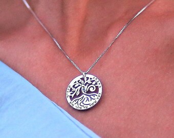 May include: A silver necklace with a tree of life pendant. The pendant is round and features a detailed design of a tree with branches and roots.