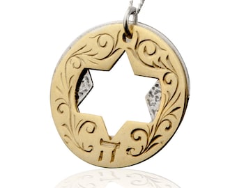 May include: A gold and silver pendant necklace featuring a Star of David with intricate floral designs. The pendant is round and has a cutout in the shape of a six-pointed star.