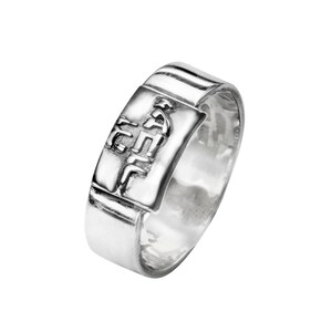 Peut inclure: Une bague en argent avec une bande rectangulaire et une inscription en hébreu en relief.