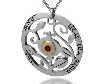 May include: Silver necklace with a round pendant featuring a pomegranate design with a red gemstone in the center. The pendant is inscribed with Hebrew text.