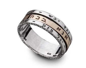 May include: A silver ring with a gold band inscribed with Hebrew text. The ring has a decorative floral pattern.