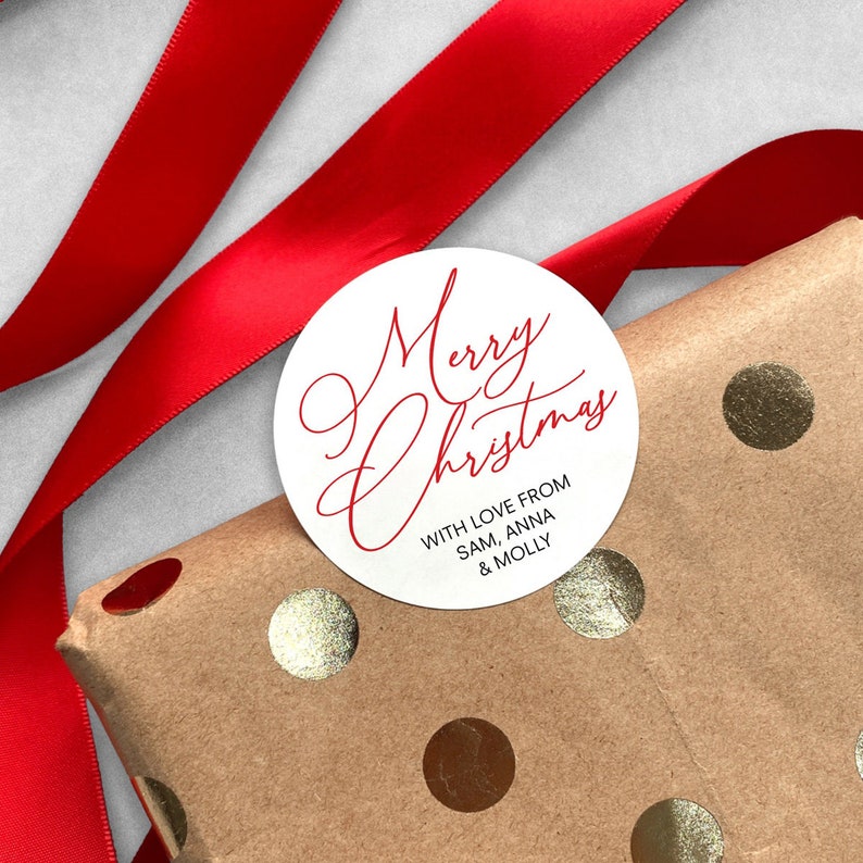 May include: White round gift tag with red cursive text that says "Merry Christmas" and the words "With love from Sam, Anna & Molly" in smaller red text.