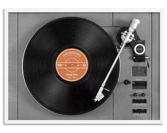 May include: A framed print of a vintage record player with a black vinyl record. The record label is orange with the text "OUR FAVOURITE" and "Song Title". The record player is gray with silver and white accents.