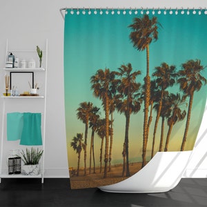 May include: A shower curtain with a tropical beach scene featuring palm trees silhouetted against a turquoise sky and a sandy beach.