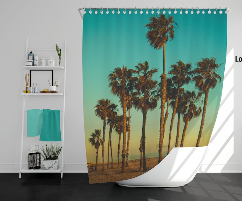 May include: A shower curtain with a tropical beach scene featuring palm trees silhouetted against a turquoise sky and a sandy beach.