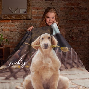 May include: A soft, brown and white fleece blanket with a photo of a golden retriever dog holding a flower in its mouth. The dog's name, "Lucky", is written in white cursive on the blanket.