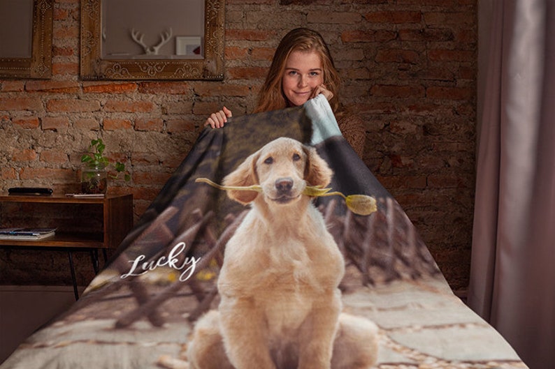 May include: A soft, brown and white fleece blanket with a photo of a golden retriever dog holding a flower in its mouth. The dog's name, "Lucky", is written in white cursive on the blanket.