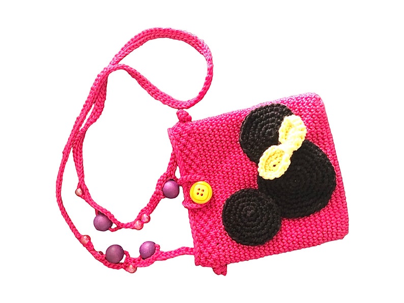 Op de afbeelding: Een roze gehaakte schoudertas met een zwart en geel gehaakt Mickey Mouse-ontwerp en een gele knoop.