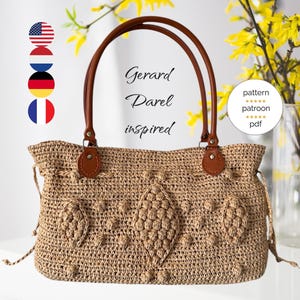Puede incluir: Un bolso de crochet con un asa de cuero marrón y un diseño en forma de diamante. El bolso está inspirado en Gerard Darel y está disponible como patrón en formato PDF.