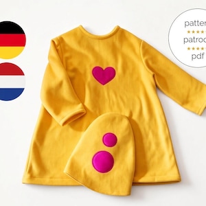 Könnte beinhalten: Ein langärmeliges gelbes Kleid mit einem pinkfarbenen Herz-Applikat auf der Brust, dazu eine passende gelbe Mütze mit zwei pinkfarbenen Kreis-Applikaten. Eine kreisförmige Grafik enthält den Text pattern, patroon und pdf mit Sternsymbolen.