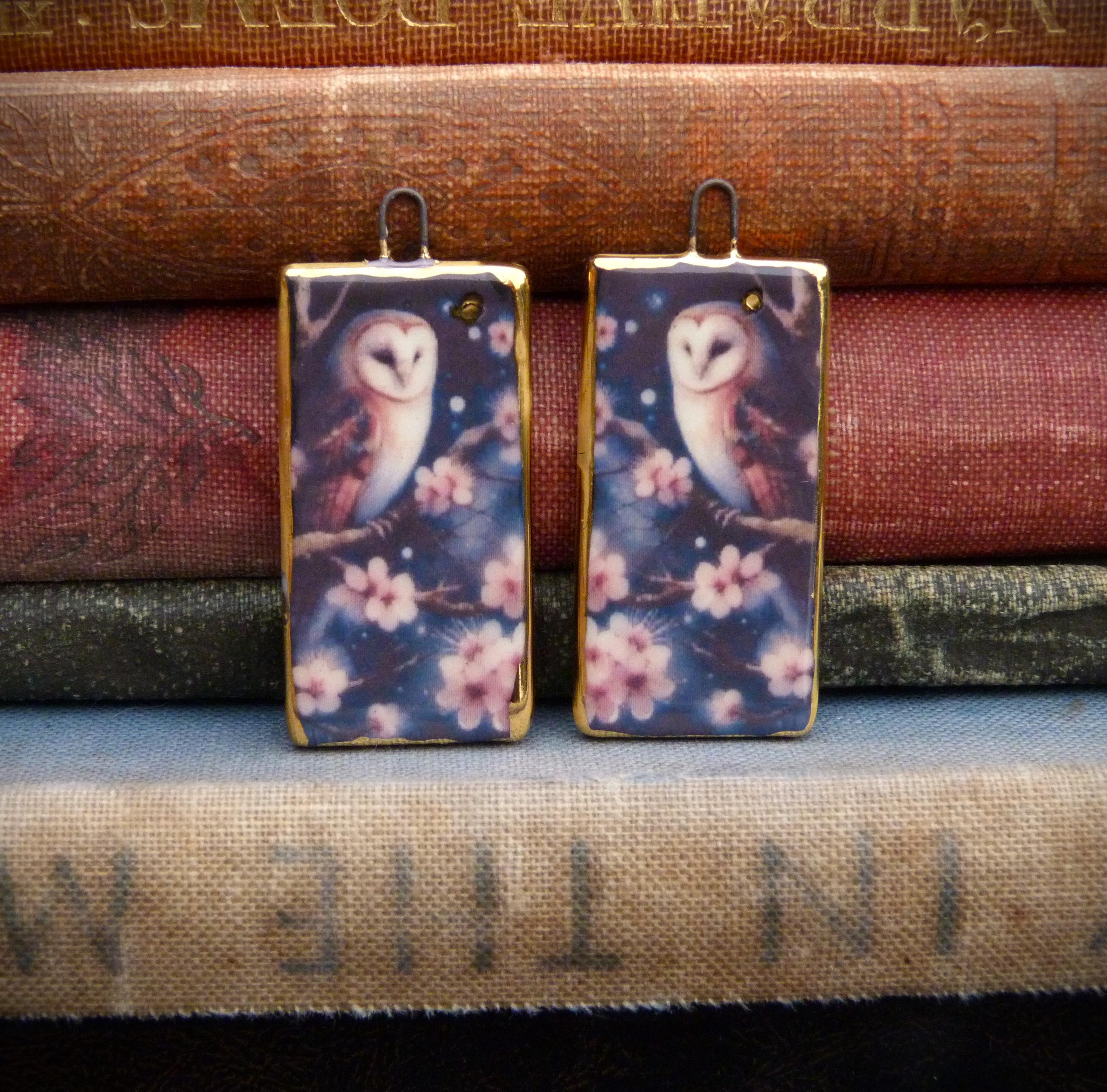 Handmade ceramic charms: illustration of an owl sat on a branch surrounded by blossom with a 24kt go