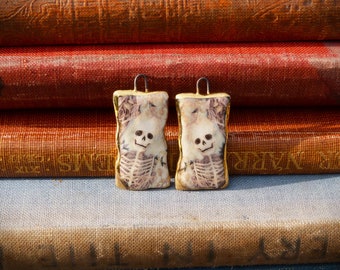 Handmade ceramic skeleton charms with a 24kt gold lustre edge.
