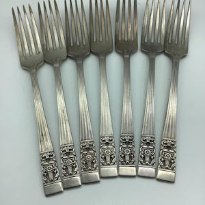 May include: Set of eight silver forks with ornate handles. The forks have a traditional design with a floral pattern.