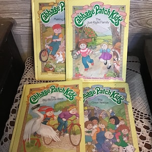 Puede incluir: Cuatro libros de cuentos vintage de Cabbage Patch Kids. Los libros tienen cubiertas amarillas con ilustraciones de niños y animales. Los títulos incluyen "Making Friends", "The Just-Right Family", "The Big Bicycle Race" y "The Great Rescue".
