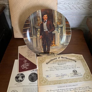 May include: A decorative plate depicting a man in a suit, set against a backdrop of a fireplace and bookshelves. Accompanied by a certificate of authenticity and other documents. Part of the "Gone With the Wind" collection.