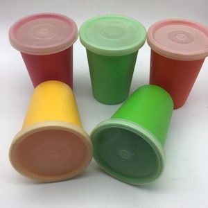 May include: Set of five colourful plastic cups with lids. The cups are red, green, yellow, and orange. The lids are white.