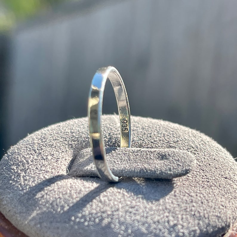 Op de afbeelding: Close-up van een zilveren ring met het nummer "935" gestempeld op de binnenkant van de band.