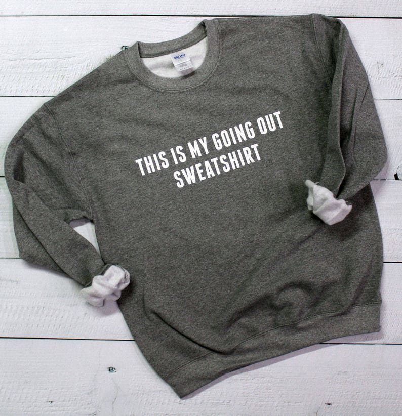 May include: A gray sweatshirt with the text "This is my going out sweatshirt" printed in white.