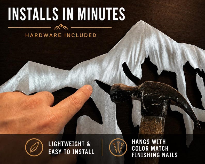 May include: A silver-colored metal mountain range wall art piece featuring a brushed finish. The text reads: INSTALLS IN MINUTES, HARDWARE INCLUDED, LIGHTWEIGHT & EASY TO INSTALL, and HANGS WITH COLOR MATCH FINISHING NAILS. A hammer is shown.