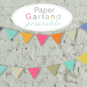 Può includere: Una ghirlanda di carta stampabile con bandierine di vari colori, tra cui giallo, blu, rosa, verde e beige. La ghirlanda è appesa a un muro di mattoni bianchi. Il testo "Paper Garland printable" è scritto in un ovale bianco sul muro.