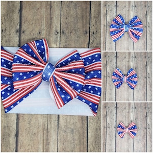 Può includere: Un cerchietto per capelli con fiocco rosso, bianco e blu con un grande fiocco al centro. Il fiocco è realizzato in tessuto con un motivo a righe rosso, bianco e blu e stelle bianche. Il cerchietto è bianco.