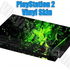 May include: A black PlayStation 2 console with a green and black splatter paint vinyl skin.
