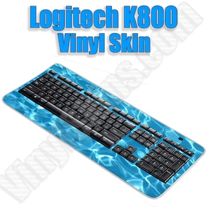 May include: A blue and black Logitech K800 keyboard with a vinyl skin featuring a water ripple design.