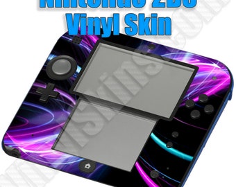 May include: A black Nintendo 2DS handheld gaming console with a colorful vinyl skin featuring swirling neon blue, pink, and purple lines on a black background. The console is closed and the top screen is visible.