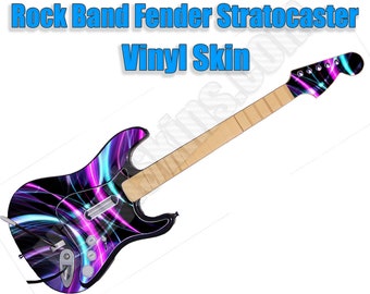 May include: A black electric guitar with a purple and blue abstract design. The guitar has a wooden neck and a black body. The guitar is a Fender Stratocaster and is for use with the Rock Band video game.