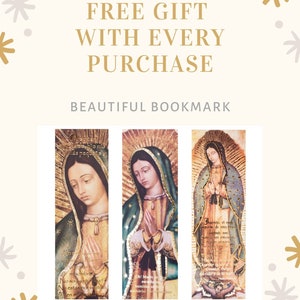 May include: Three bookmarks featuring a religious image of the Virgin Mary. The bookmarks are gold and have a religious inscription in Spanish. The bookmarks are on a white background with gold and gray stars.