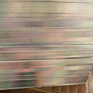 May include: A stack of iridescent playing cards with a slight shimmer. The cards are stacked neatly and are ready for a game.