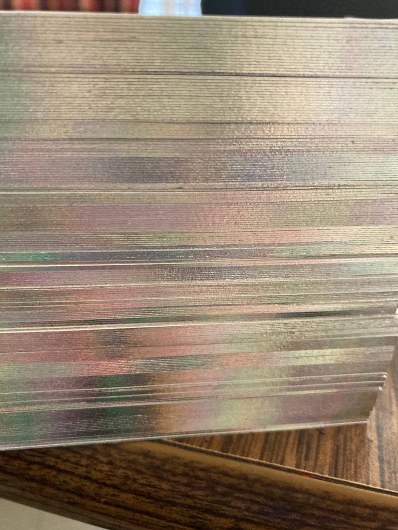 May include: A stack of iridescent playing cards with a slight shimmer. The cards are stacked neatly and are ready for a game.