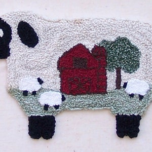 May include: A white sheep rug with black legs and a black face. The sheep is standing in a field with a red barn, a green tree, and three smaller white sheep.