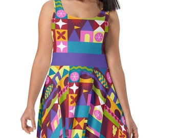 Puede incluir: Un vestido sin mangas colorido con un patrón geométrico que presenta un castillo, estrellas y otras formas. El vestido tiene un corpiño ajustado y una falda acampanada.