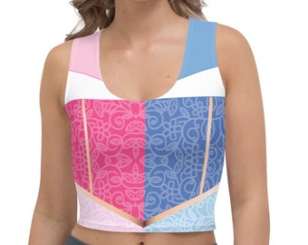 Könnte beinhalten: Ein ärmelloses Crop-Top mit geteiltem Design. Eine Seite ist rosa mit einem Blumenmuster, die andere ist blau mit einem ähnlichen Design. Das Oberteil hat weiße und pfirsichfarbene Akzente und wird mit grauen Leggings getragen.