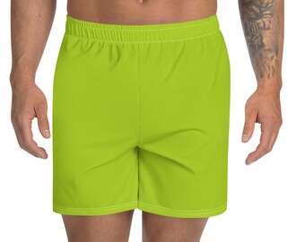 Puede incluir: Pantalones cortos deportivos de color verde lima brillante con cintura elástica. Los pantalones cortos llegan a la rodilla y parecen estar hechos de una tela ligera y transpirable. El modelo lleva zapatillas deportivas blancas.
