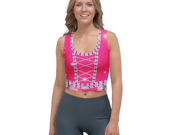 May include: A sleeveless crop top in a vibrant pink hue, featuring a design reminiscent of a corset. The top is adorned with white and purple diamond-shaped accents and a criss-cross pattern. The garment is designed to be form-fitting.