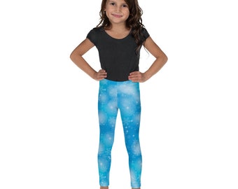 May include: A young person wearing a black short-sleeved top and blue leggings with a snowflake pattern.