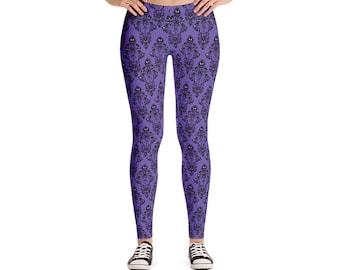May include: Purple leggings with a black and white repeating pattern of a haunted mansion. The pattern includes a ghost with a mischievous grin.