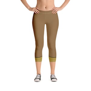 Puede incluir: Leggings capri marrones con una banda dorada en la parte inferior de cada pierna.