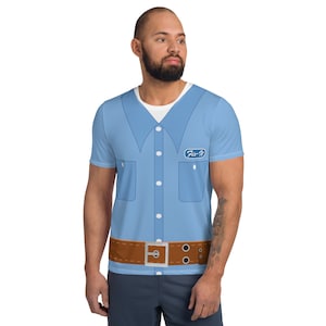 May include: A blue short-sleeved t-shirt with a button-down shirt design. The shirt has a brown belt and a name tag that says "Fix-It".